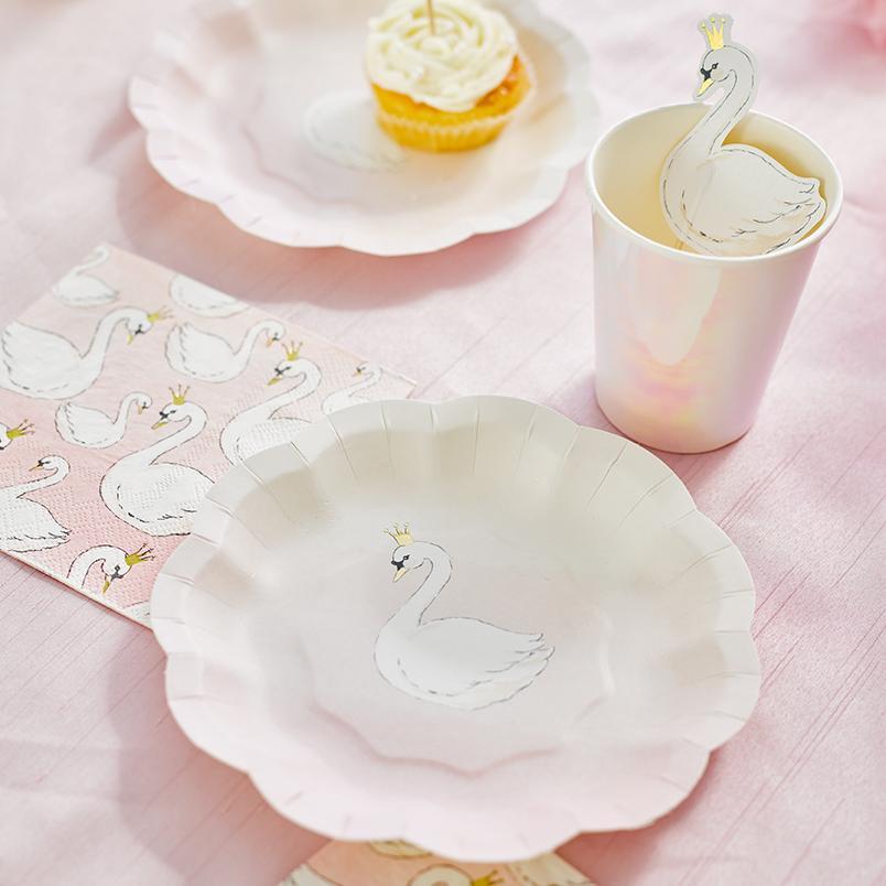 Märchenstimmung auf dem Kindergeburtstag dank Partygeschirr mit Schwänen auf pastellfarbenem Hintergrund Märchenstimmung auf dem Kindergeburtstag dank Partygeschirr mit Schwänen auf pastellfarbenem Hintergrund