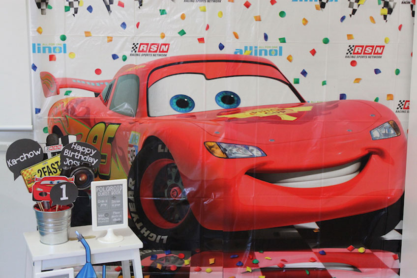 Beispielsweise eine große Tischdecke lässt sich perfekt als Photobooth-Hintergrund umwandeln. Eine Photobooth mit den Stars aus Pixars "Cars" ist eine tolle Aktivität für den Kindergeburtstag.