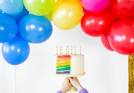 Back eine bunte Regenbogentorte für die Mottoparty