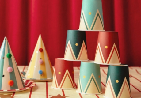 Muster und Farben der fröhlichen Zirkus-Pappbecher und Partyhüte erinnert an ein Clownskostüm